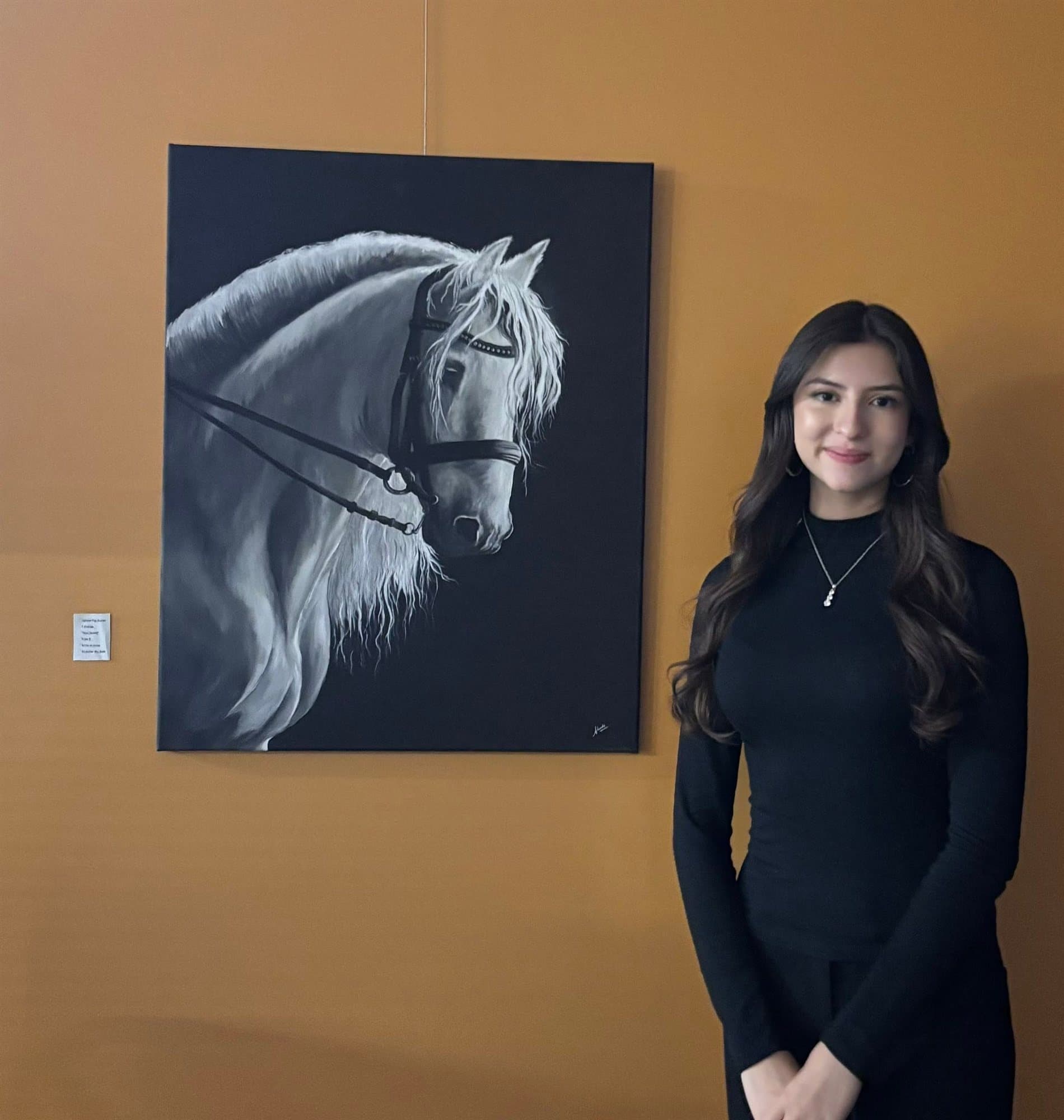 A Highland Prep student with a painting of a horse