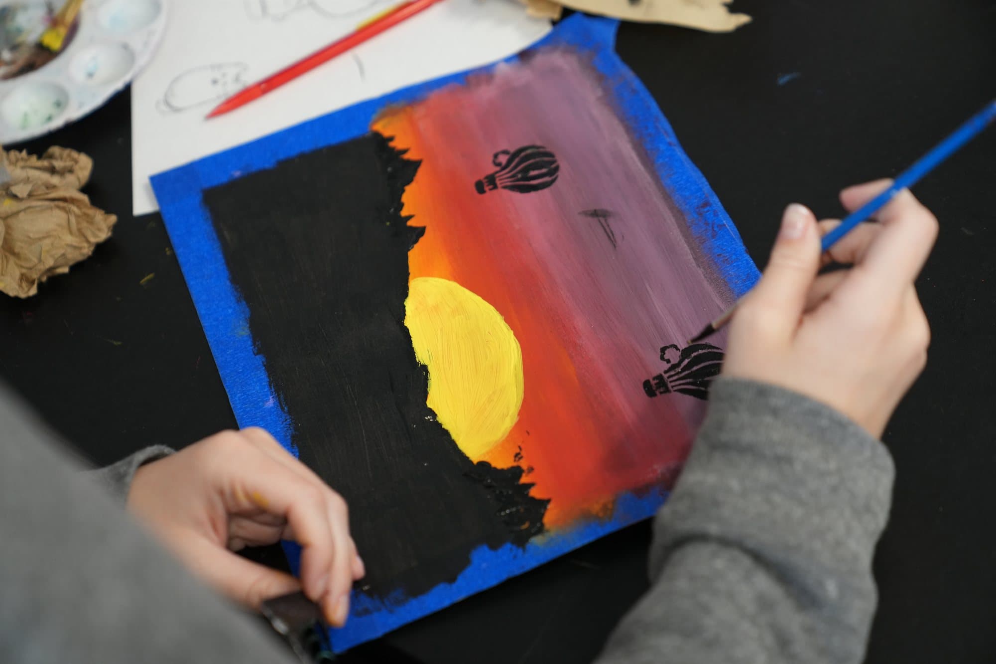 A Highland Prep art student painting a hot air balloon scene