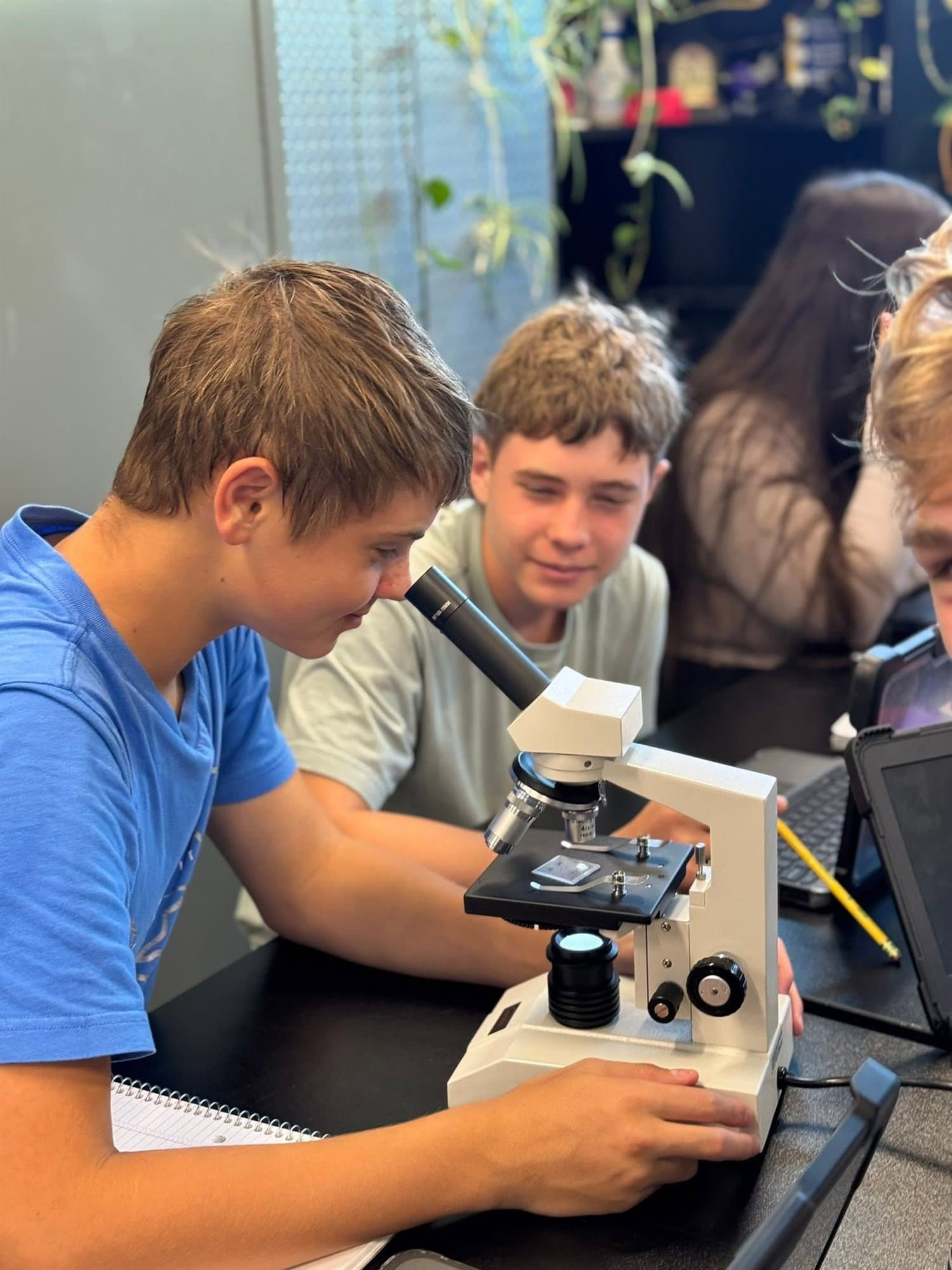 Highland Prep students examining a slide under the microscope