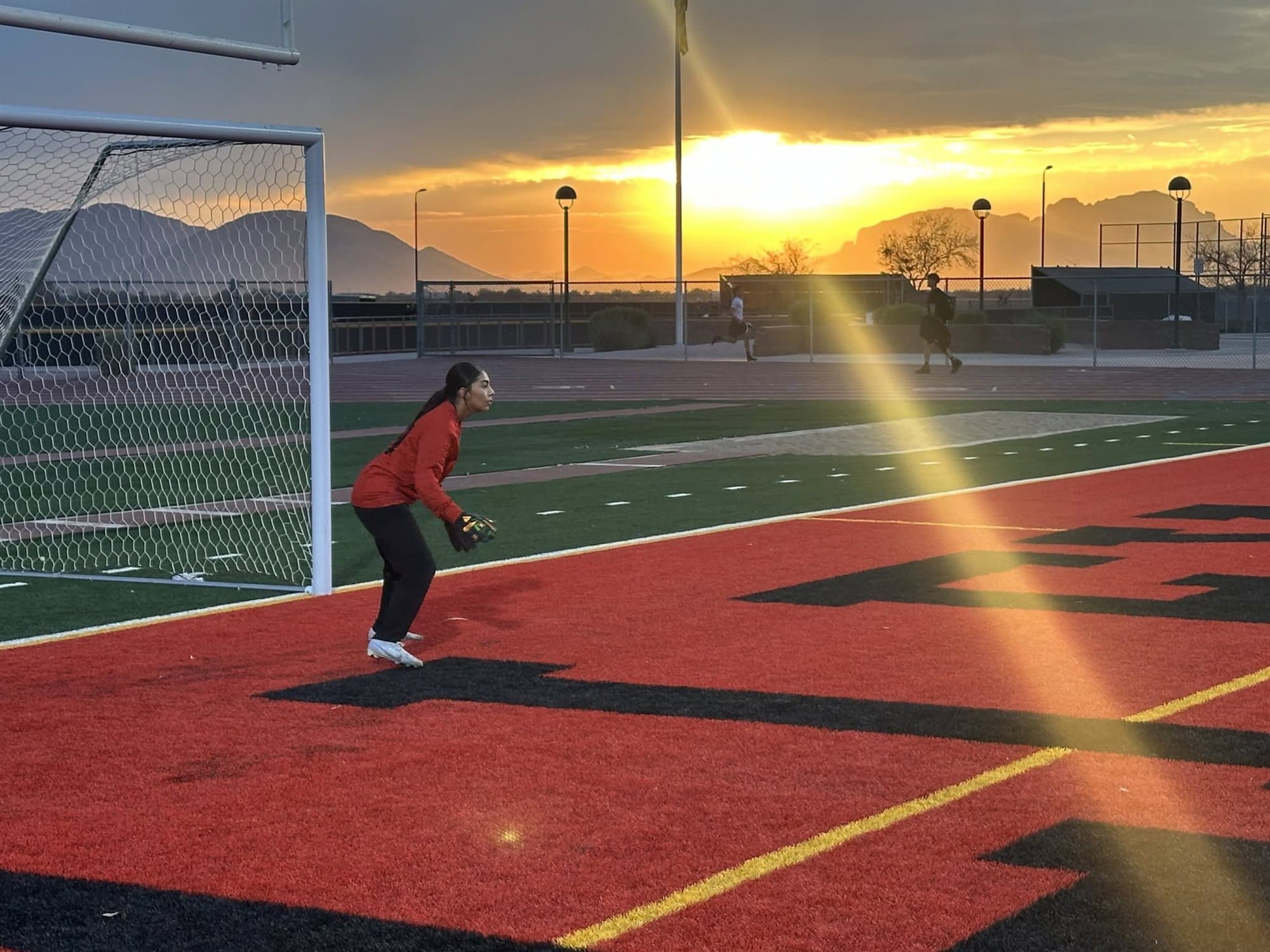 A Highland Prep goalkeeper guarding the net at sunset