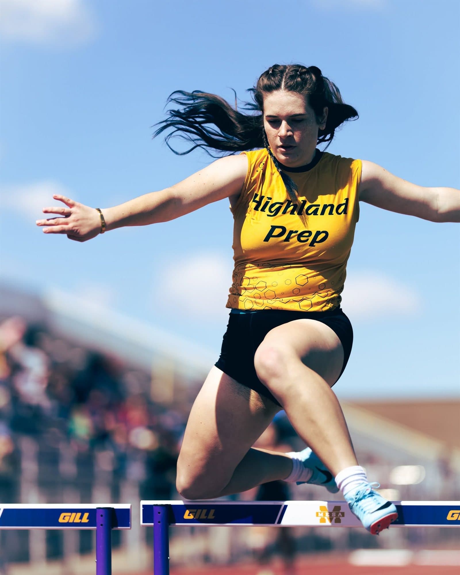 A Highland Prep hurdler clearing a hurdle