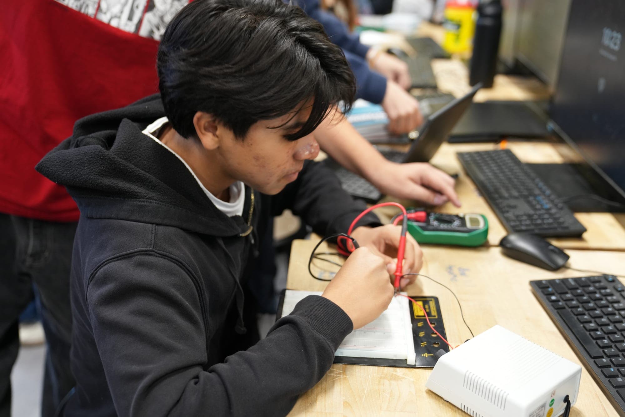 A Highland Prep student testing a circuit at a classroom workstation