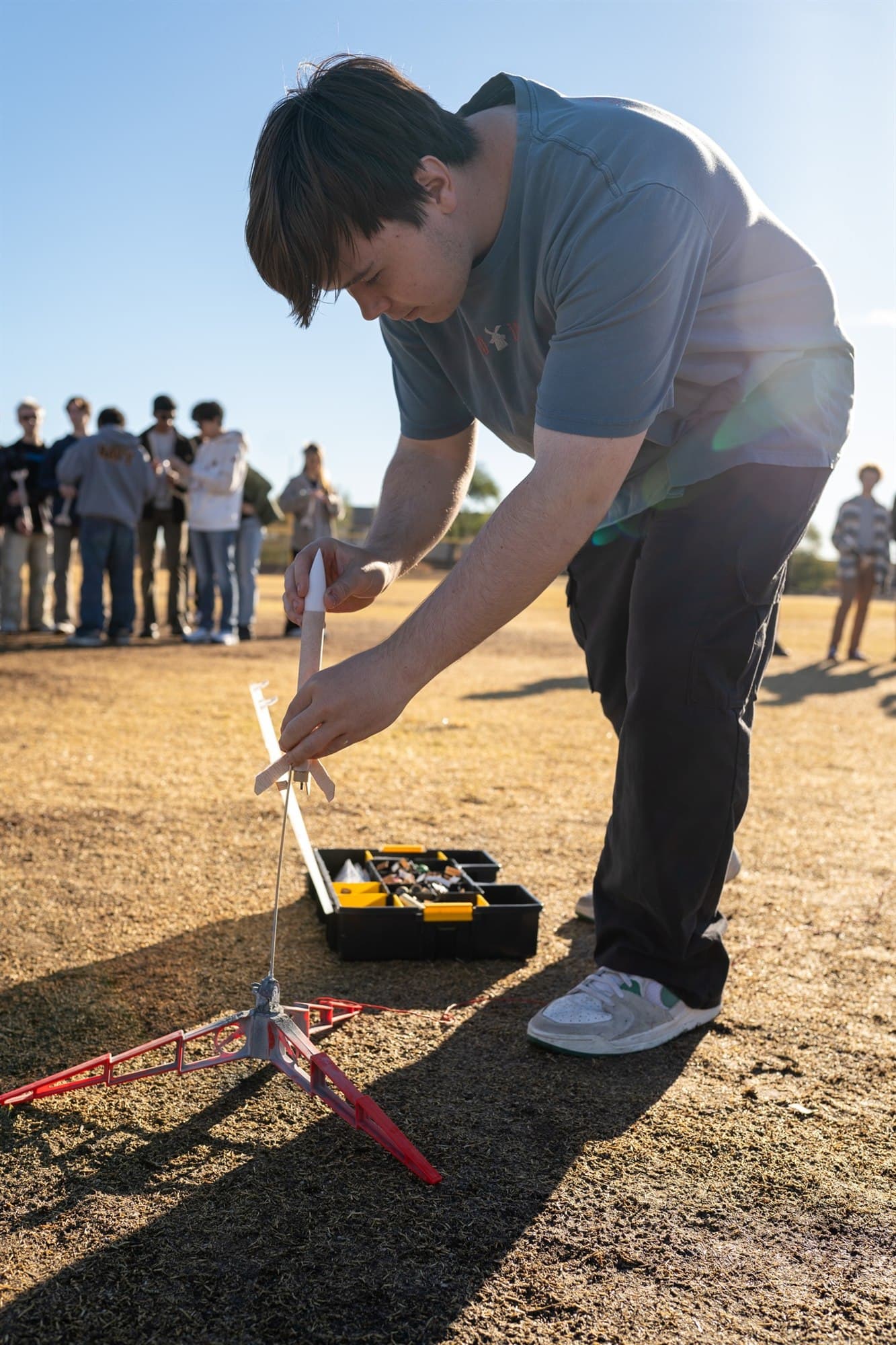 Highland Prep student preparing a model rocket for launch