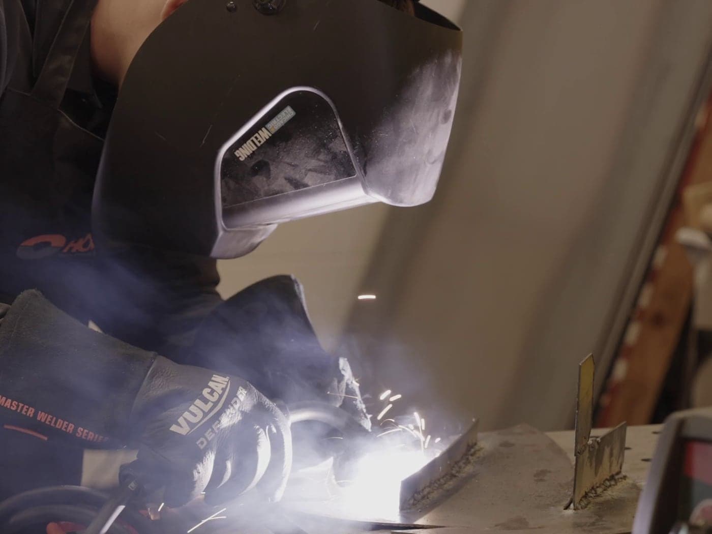 Highland Prep student welding in protective gear in the fabrication shop