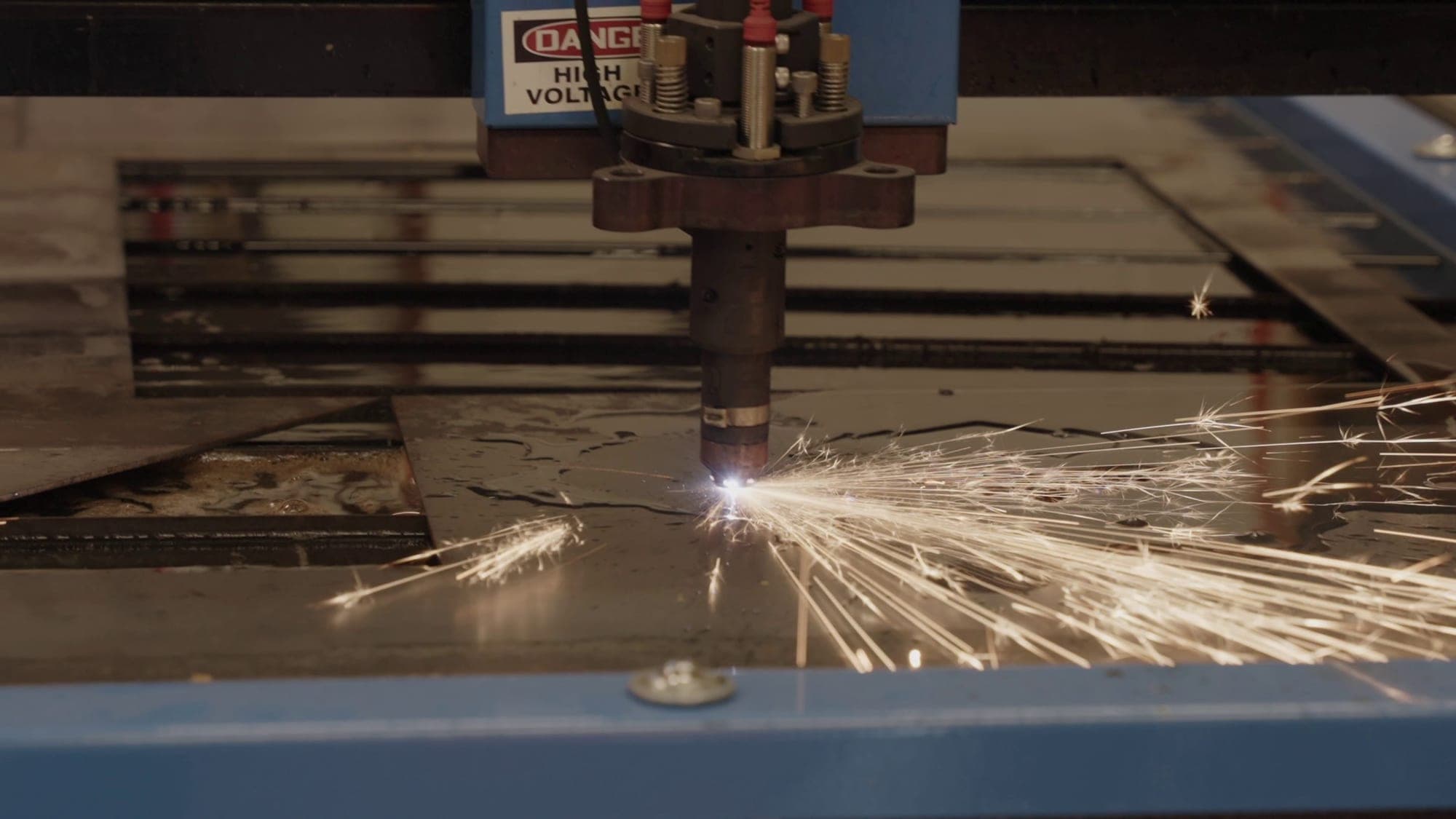 A CNC plasma cutter cutting steel plate in the Highland Prep fabrication shop