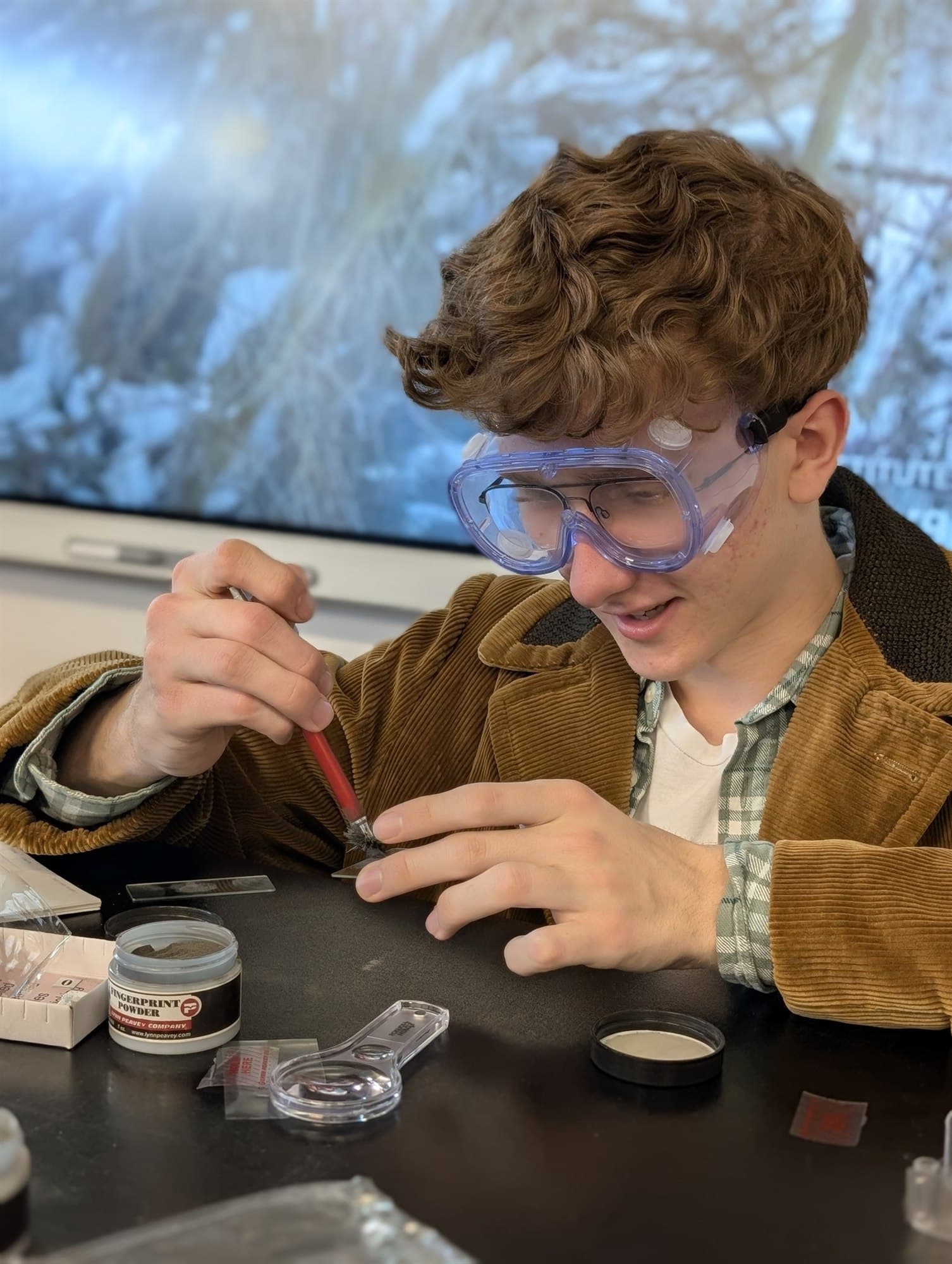 Highland Prep student dusting for fingerprints in a forensic science lab